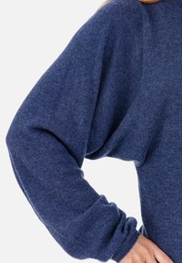 Dunkelblauer Strickpullover mit lockerem Schnitt, fällt über die Schultern, mit weiten Ärmeln und gerippten Bündchen für zusätzliche Struktur.