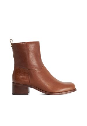Bottine en cuir marron avec un talon bloc bas et une languette à l'arrière, montrée de côté extérieur sur fond blanc.