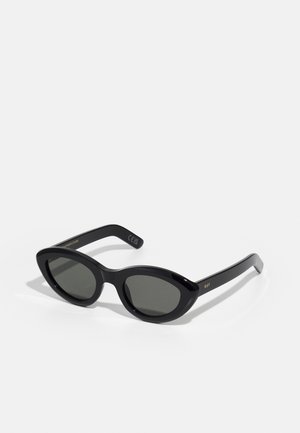 Occhiali da sole neri con una forma arrotondata a occhio di gatto e lenti scure. Realizzati in plastica lucida, con testo dorato subtile sulle astine.