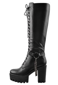 Black knee-high boot made of smooth leather with a chunky platform heel, lace-up front, and a decorative chain accent on a strap.