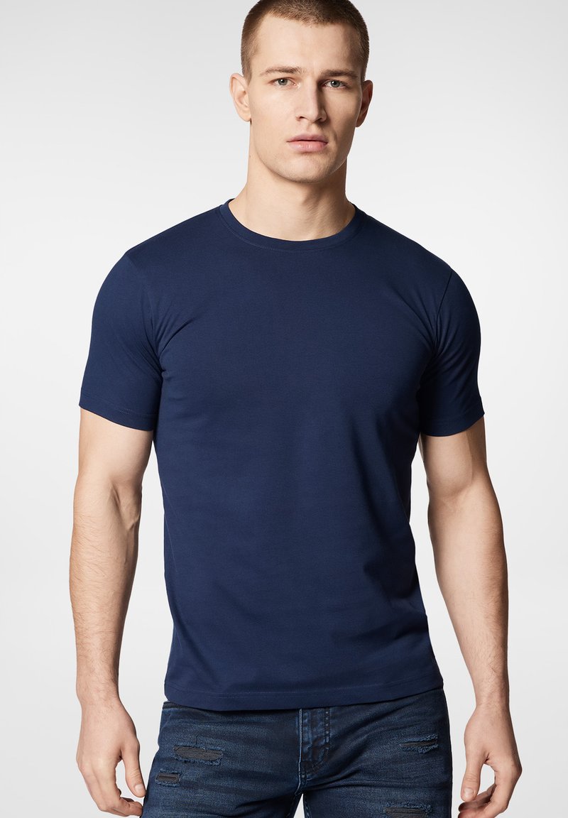 Granatowa bawełniana koszulka z krótkim rękawem, okrągłym dekoltem i dopasowanym krojem. Gładka tekstura bez wzorów i ozdób.