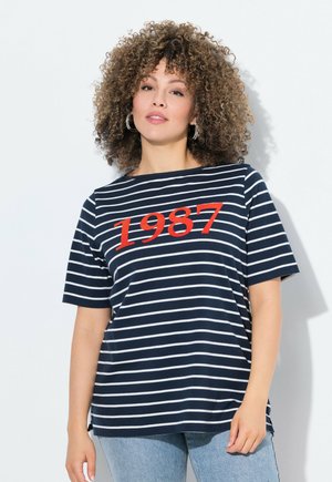 T-shirt bleu marine à rayures avec des manches courtes, présentant des rayures horizontales blanches et un graphique rouge "1987" en évidence sur le devant.