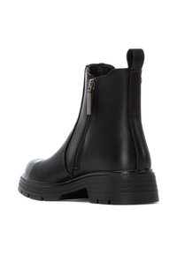Stivaletto in pelle nera con zip laterale, forma affusolata, superficie testurizzata e suola in gomma robusta. Con linguetta sul retro per una facile calzata.