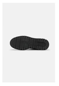 Semelle de chaussure en caoutchouc noir avec un motif texturé et des rainures profondes pour une meilleure adhérence. Présente un logo en relief "marco polo" près du centre.