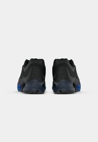 Pair of black athletic shoes with blue soles, shown from the back on a plain white background.