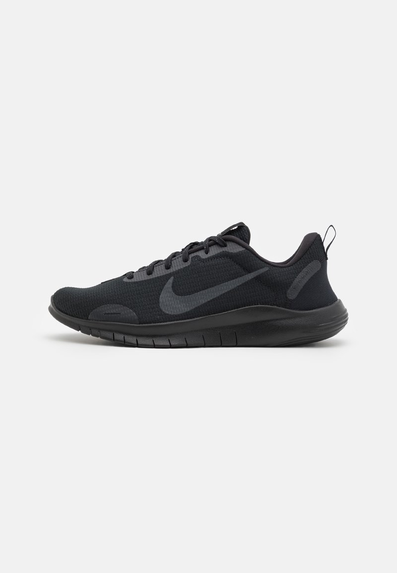 Chaussure de sport noire en tissu texturé, modèle à lacets avec logo Nike Swoosh gris foncé sur le côté, vue de profil sur fond blanc.