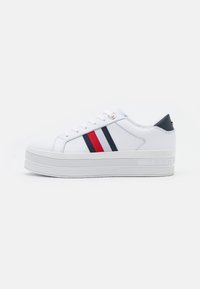 Weißer Sneaker mit dicker Sohle, ausgestattet mit blauen und roten Streifen. Glattes Synthetikmaterial mit einem Schnürverschluss und Logodetail an der Seite.