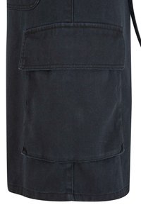 Dark denim skirt featuring a large front pocket, straight cut, and visible stitching. Fabric has a smooth texture with a subtle sheen.