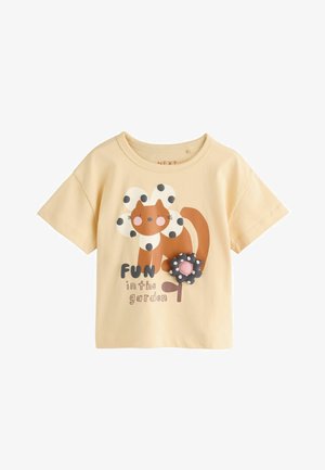 Kort beige børnet-shirt med en tegneserie kat iført en blomsterkrave og tekst "Fun in the garden" med en 3D-prikket blomst.