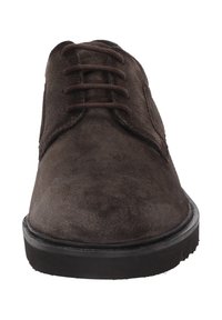 Chaussure en daim marron à lacets, avec un bout arrondi et une semelle noire plate. La surface a une texture douce et ne présente aucun motif visible ni détail matériel.