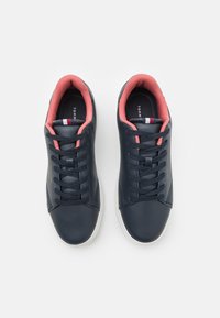 Sneaker in pelle blu navy con colletto e linguetta rosa, dotate di suola bianca, sei occhielli, punta tonda e marchio sui lati e sulla soletta.