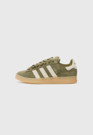 Baskets basses en daim vert olive avec des bandes blanches, semelle en gomme et lacets, vues de côté droit sur fond uni.