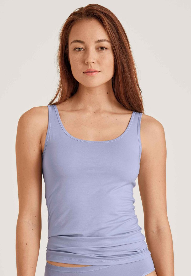 Light purple tank top made of smooth fabric, featuring a slim fit and wide straps. The design is simple with no visible patterns or accents.