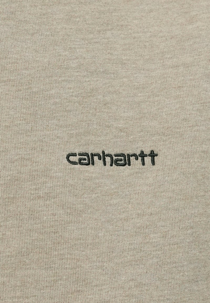 Beige bomulds t-shirt med ribbet tekstur og kontrastfuldt sort broderet logo "carhartt" på forsiden.