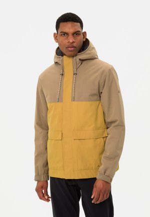 Wasserabweisende Jacke mit einem oberen Abschnitt in Beige und einem unteren Abschnitt in Senfgelb, mit Kapuze, Kordelzugverschluss und frontalen Taschen.