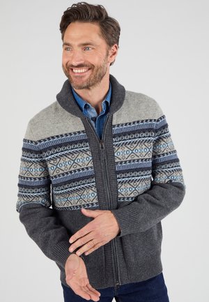 Cárdigan gris con cremallera y yugo estampado en azul y blanco. Presenta un cuello de chal y puños acanalados, hecho de un tejido de punto texturizado.