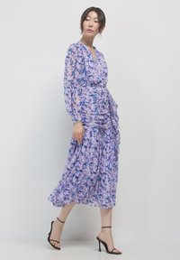Abito midi con stampa floreale in tessuto viola trasparente, dotato di maniche lunghe, design avvolgente, dettagli arricciati e orlo a strati.