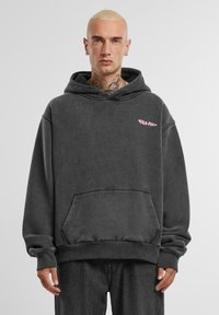Kapuzenpullover in anthrazitgrau aus weichem Stoff, mit einer Kängurutasche, gerippten Bündchen und einem kleinen pinken Logo auf der Brust.