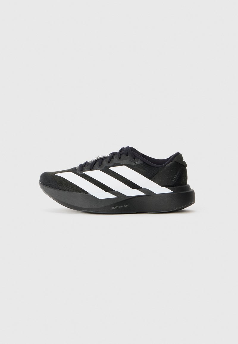 Baskets de course noires avec un design à trois rayures blanches, semelle épaisse portant l'étiquette "Lightstrike Pro" et lacets noirs, profil latéral sur fond blanc.