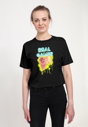 Zwarte T-shirt met korte mouwen, voorzien van een kleurrijke neonprint van een gamecontroller met de tekst "Echte GAMER", tegen een heldere achtergrond.