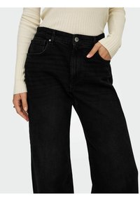 Sorte bredbenede jeans med høj talje, forlommer og metalknaplukning. Har en blød denimstruktur og subtile folder.
