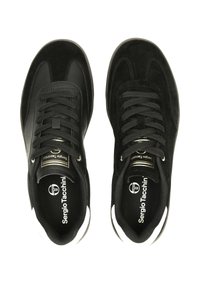 Černé tenisky s kombinací semiše a syntetických materiálů, kulatá špička, ploché šnurování a bílý akcent na podrážce. Logo značky na jazyku.