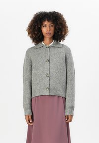 Cardigan grigio a maglia con collo a camicia, orlo e polsini a costine, dotato di cinque bottoni sul davanti. Tessuto morbido e strutturato.