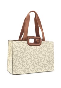 Bolso tote crema con patrón abstracto en gris, que presenta un asa rectangular marrón y paneles laterales en marrón contrastante. Textura suave.