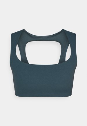 Dark teal sports bra with a rounded neckline, wide straps, and an open back design. Smooth texture and clean lines characterize its shape.