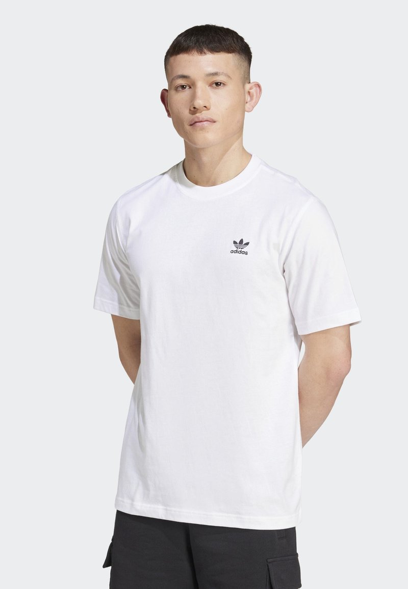 Bílý bavlněný tričko s kulatým výstřihem a krátkými rukávy. Na levé hrudi se nachází malé černé logo Adidas. Jednoduchý a solidn�í design.