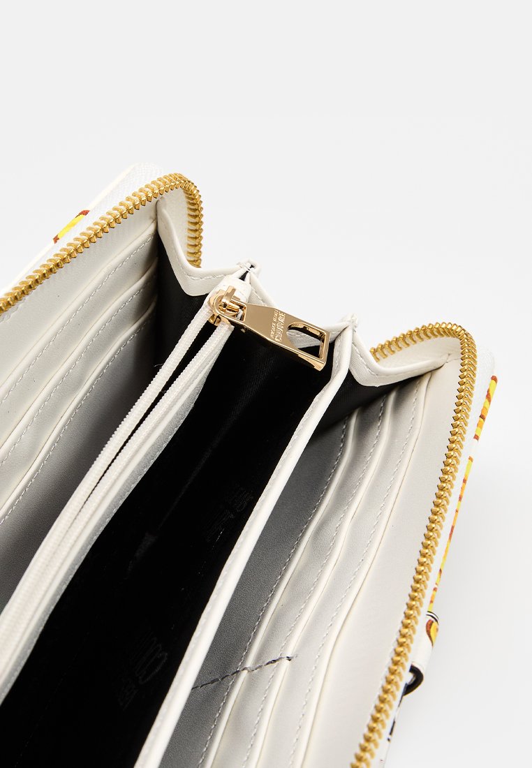 Cartera con cremallera y un interior blanco, múltiples ranuras para tarjetas y una cremallera dorada. Presenta una textura suave y un exterior colorido con patrones.