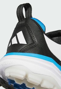 Μαύρο αθλητικό παπούτσι με μπλε λεπτομέρειες και λευκές διακοσμήσεις. Διαθέτει υφασμάτινη υφή, μεγάλο λευκό λογότυπο και παχύ πέλμα με έντονα σχέδια.