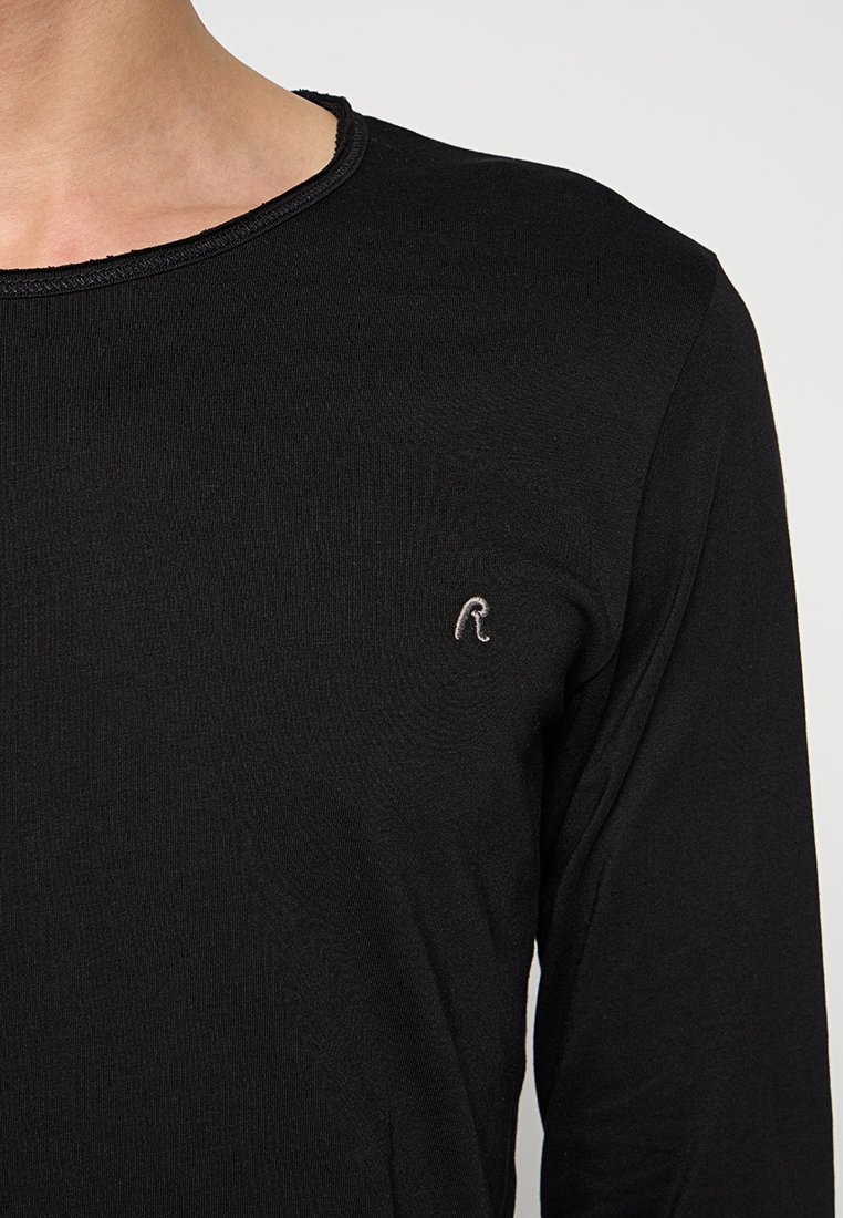 Schwarzes Langarm-T-Shirt mit geripptem Kragen und kleinem gesticktem Logo auf der Brust. Das Material ist glatt und leicht dehnbar.