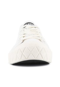 Vit canvas sneakers med gummisula som har ett texturerat diamantmönster. Snörningarna är ljusbeiga och tungan har "PALLADIUM"-logotypen.