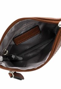 Sacca in pelle marrone con interno grigio, dotata di chiusura con zip, etichetta del marchio impressa, e una penna all'interno.