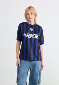 Jersey de Nike a rayas azul marino y azul con mangas cortas, que presenta un destacado logo blanco en la parte frontal y un escote redondo.