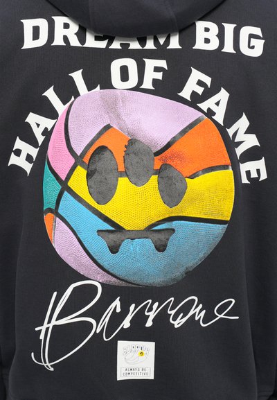 Sudadera negra con un gran gráfico de baloncesto colorido que tiene una cara sonriente, texto "SUEÑA EN GRANDE SALA DE LA FAMA" y el logo de la marca.