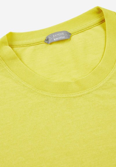 Camiseta de algodón amarilla con cuello redondo, que presenta una textura suave y un detalle de costura mínimo. La etiqueta dice "Zanone icecotton."