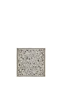 Tela cuadrada de patrón blanco y negro con diseños florales; presenta un borde texturizado y detallado, con intrincados elementos a lo largo.