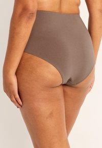 Högmidjade bruna bomullsunderkläder med en slät yta och minimal sömnad, med en medelhög skärning och full täckning.