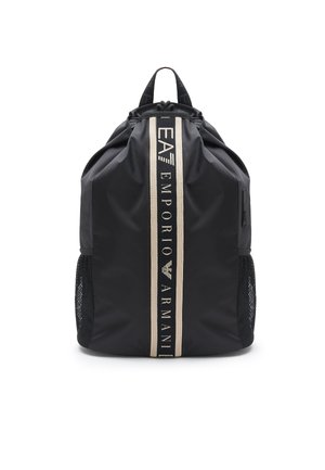Zaino in nylon nero con apertura cinchata, dettagli del logo in marrone e tasche laterali in rete per la ventilazione. Texture liscia e forma strutturata.