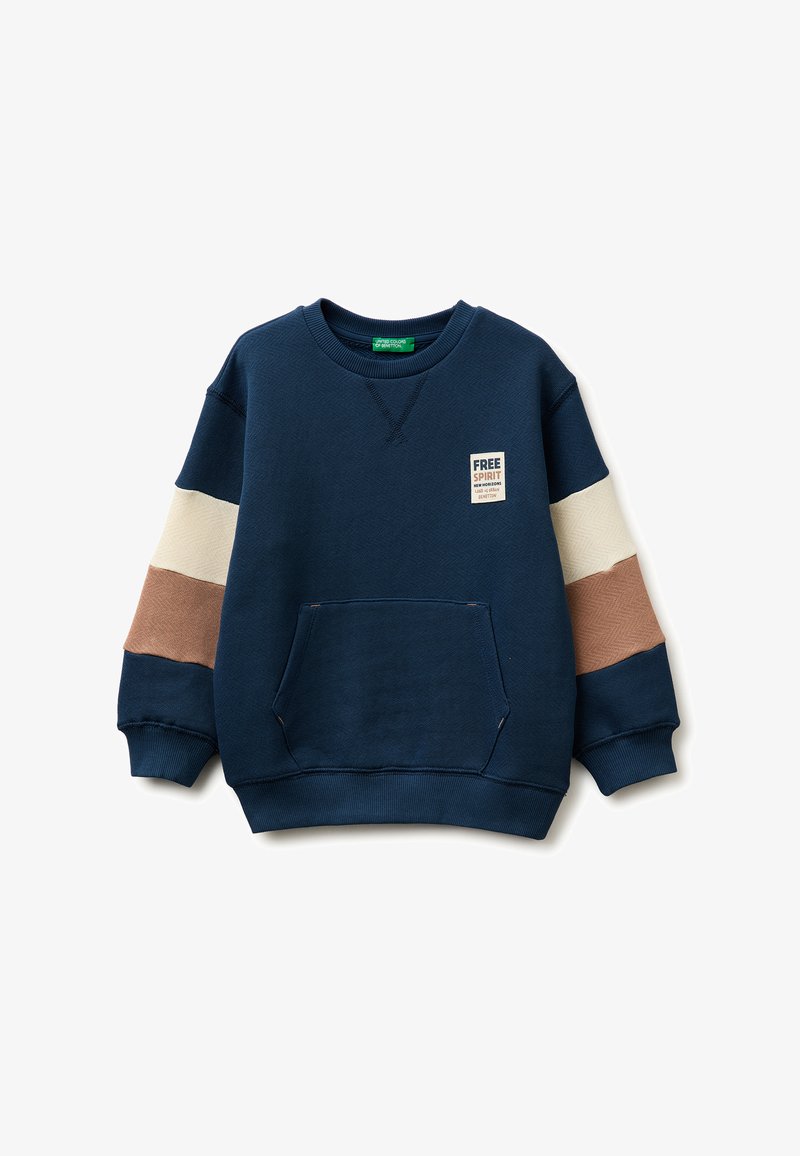 Marineblauer Pullover mit beigen und braunen Ärmelstreifen, Fronttasche und "Free Spirit"-Aufnäher auf der Brust.