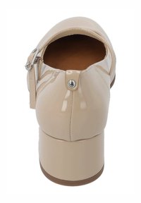 Talons en cuir verni beige avec bout arrondi, bride de cheville et boucle en argent. Dispose d'un talon cylindrique épais et d'une texture lisse.