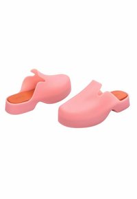 Sabots en caoutchouc rose avec une texture lisse, une forme arrondie et un dos ouvert. Présentent une semelle intérieure douce orange et une large ouverture pour les orteils.