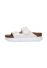Sandali bianchi slip-on con due cinturini regolabili, soletta in sughero e suola in gomma bianca. Materiale liscio con design minimalista.