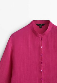 Chemise rose vif à manches longues avec col mandarin et une rangée verticale de boutons assortis au centre devant.