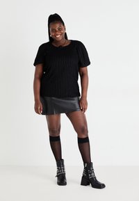 Black ribbed knit sweater, black faux leather mini skirt, sheer black thigh-highs with two stripes, and black ankle boots with studs.