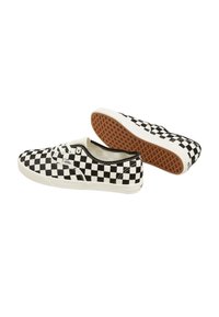 Black and white checkerboard canvas sneakers with a rubber sole, featuring white laces and a rounded toe design.