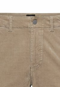 Beige fløjl bukser med regular fit, forlommer, sølvknaplukning og synlig ribbet tekstur.