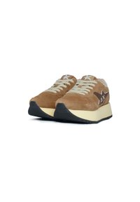 Sneaker in suede marrone con lacci crema, colletto imbottito e dettagli marroni a contrasto. Presenta una suola in gomma nera testurizzata e un intersuola ammortizzata.